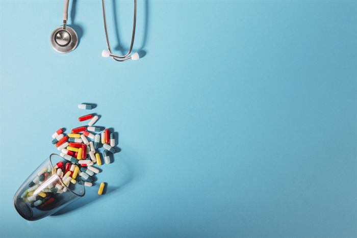 Capsules and a stethoscope arranged on a blue surface